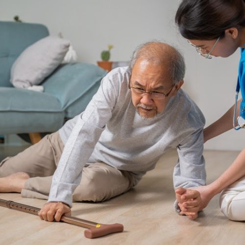 Asian older senior man falling down on lying floor and woman nurse came to help support, Disabled elderly old man patient fall down and caring young assistant at nursing home