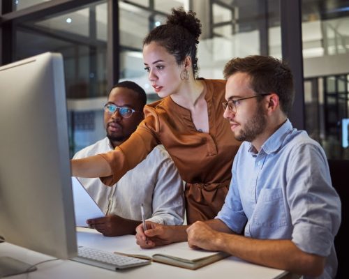 Learning, computer and training business interns in night office with manager, boss and leadership help. Men with technology planning ideas, kpi strategy and marketing innovation vision with mentor