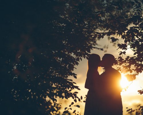 Romantic couple on sunset under the tree