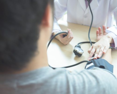 Doctor checking  patient arterial blood pressure.