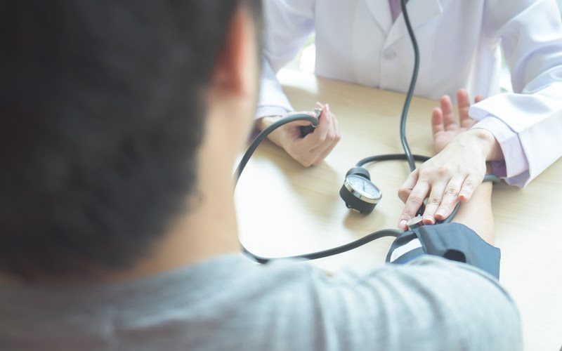 Doctor checking  patient arterial blood pressure.