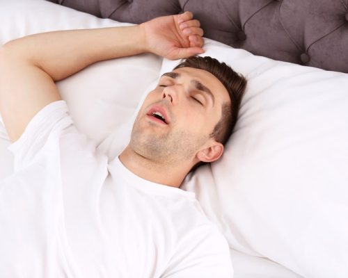 Young man sleeping in bed at home