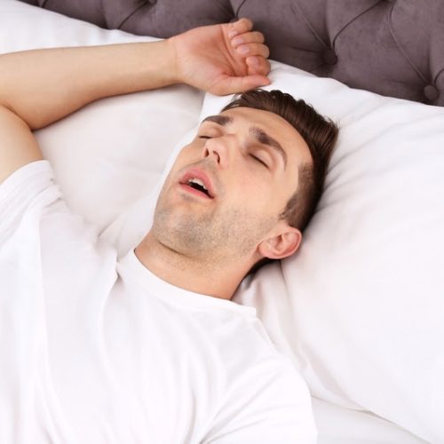 Young man sleeping in bed at home