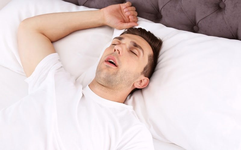 Young man sleeping in bed at home