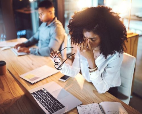 Business, woman and headache from eye strain at desk with stress, overworked and work deadline at night. Professional, employees and fatigue in coworking office with burnout, internet glitch and pain