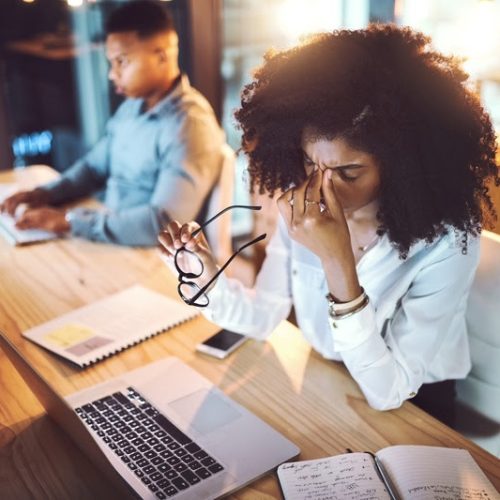 Business, woman and headache from eye strain at desk with stress, overworked and work deadline at night. Professional, employees and fatigue in coworking office with burnout, internet glitch and pain