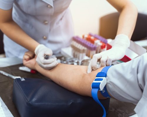 A nurse is taking a patient's blood test.