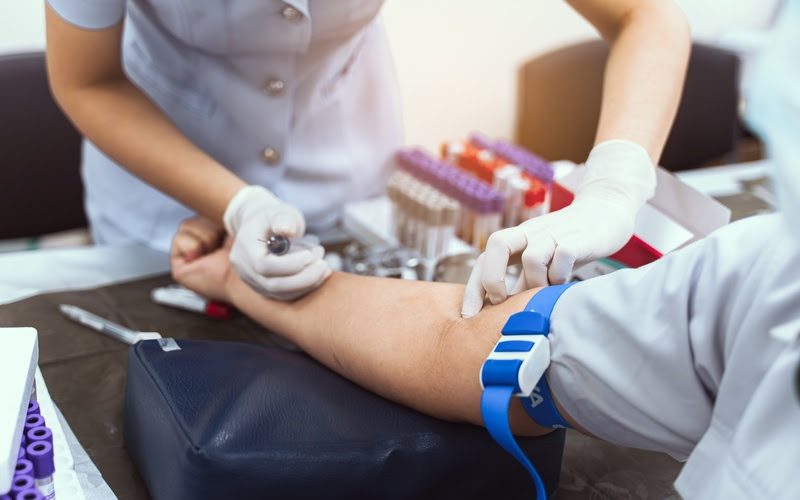 A nurse is taking a patient's blood test.