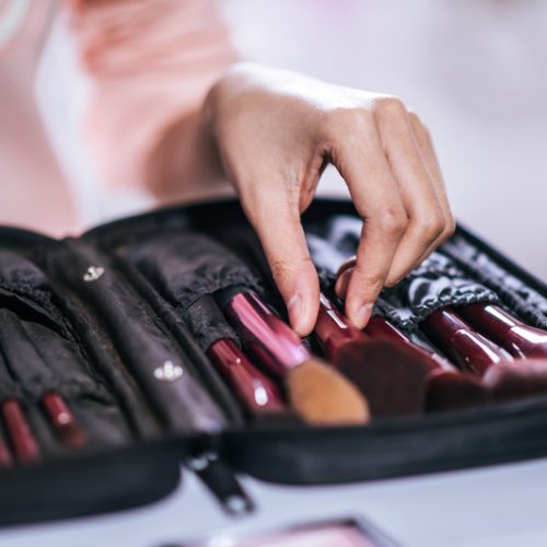 Women doing makeup with brush and cosmetic
