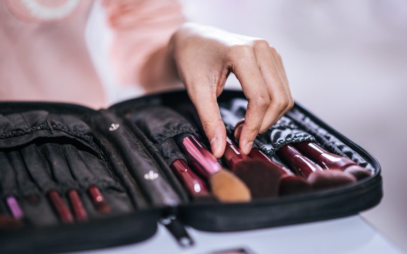 Women doing makeup with brush and cosmetic
